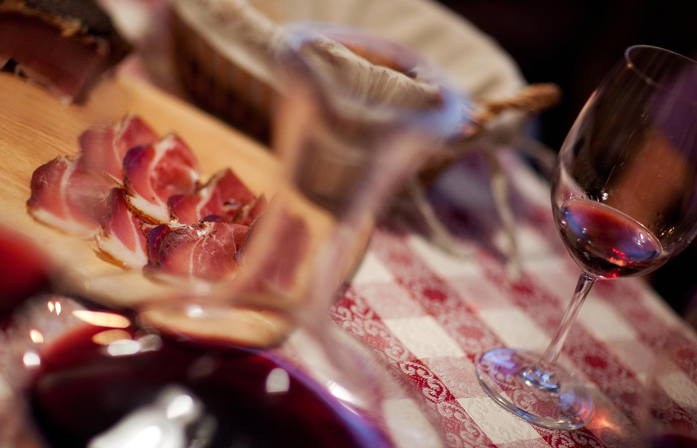 Un tagliere di speck accompagnato da vino rosso all'Hotel Cavallino