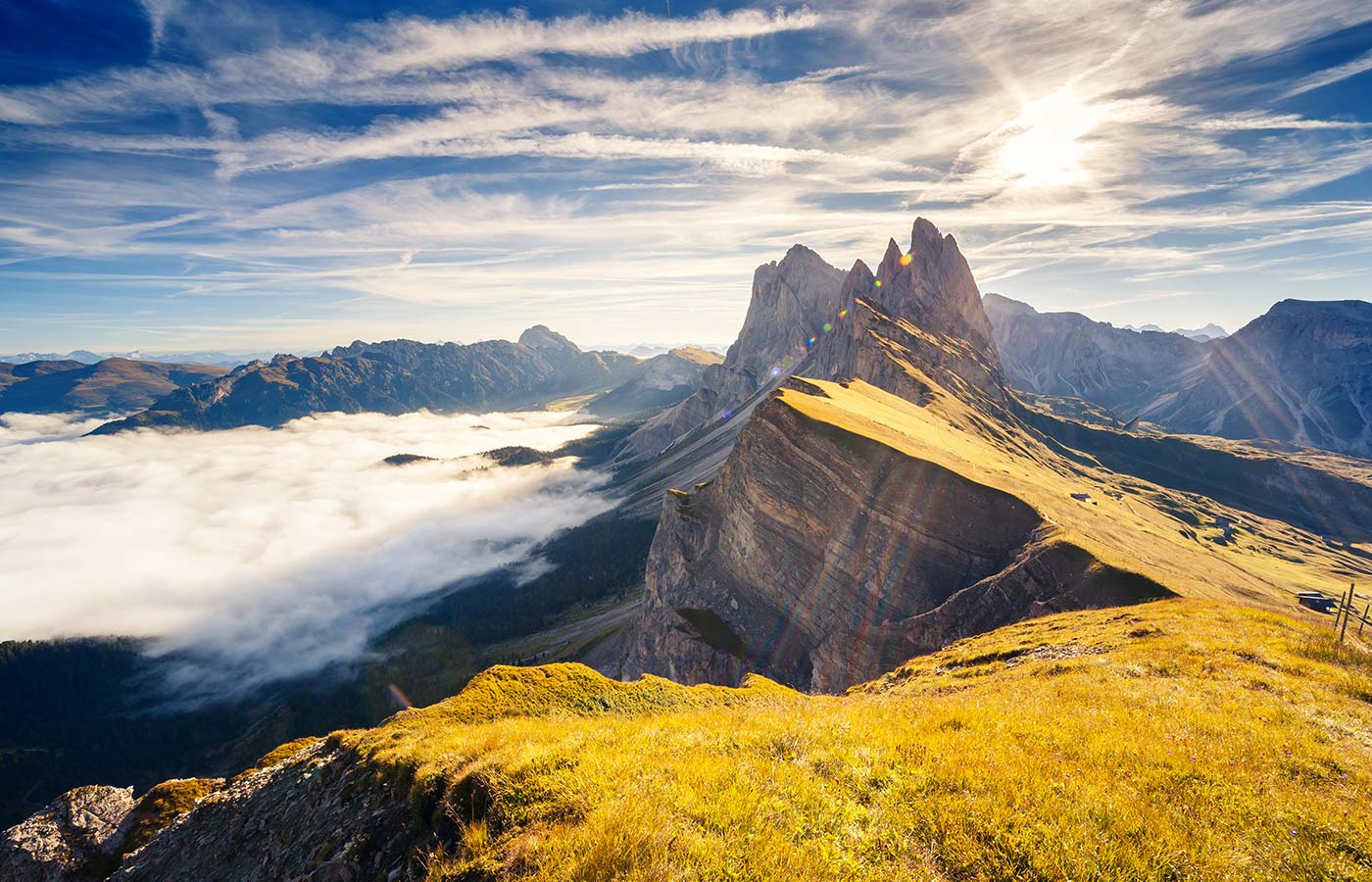 Blick auf die sonnenbeschienen Dolomiten mit einigen Wolken